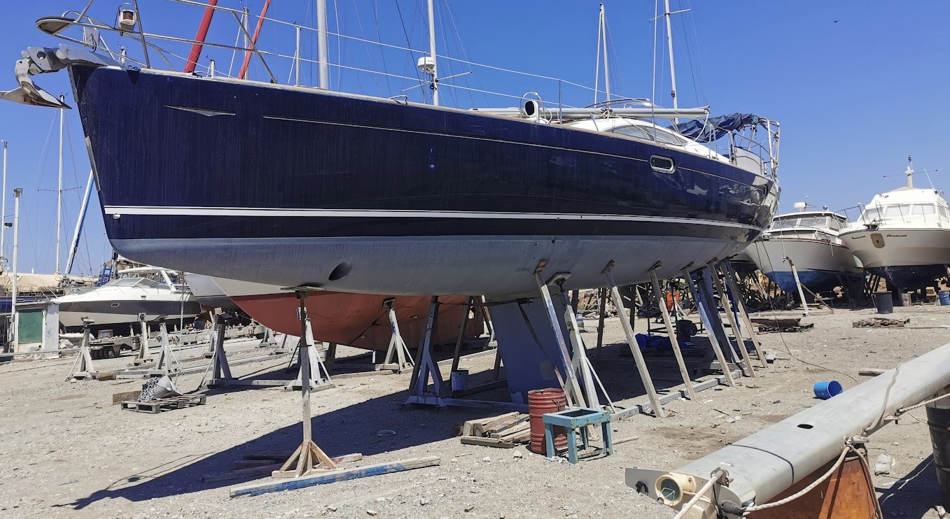 Blue yacht supported by boat stands at marina